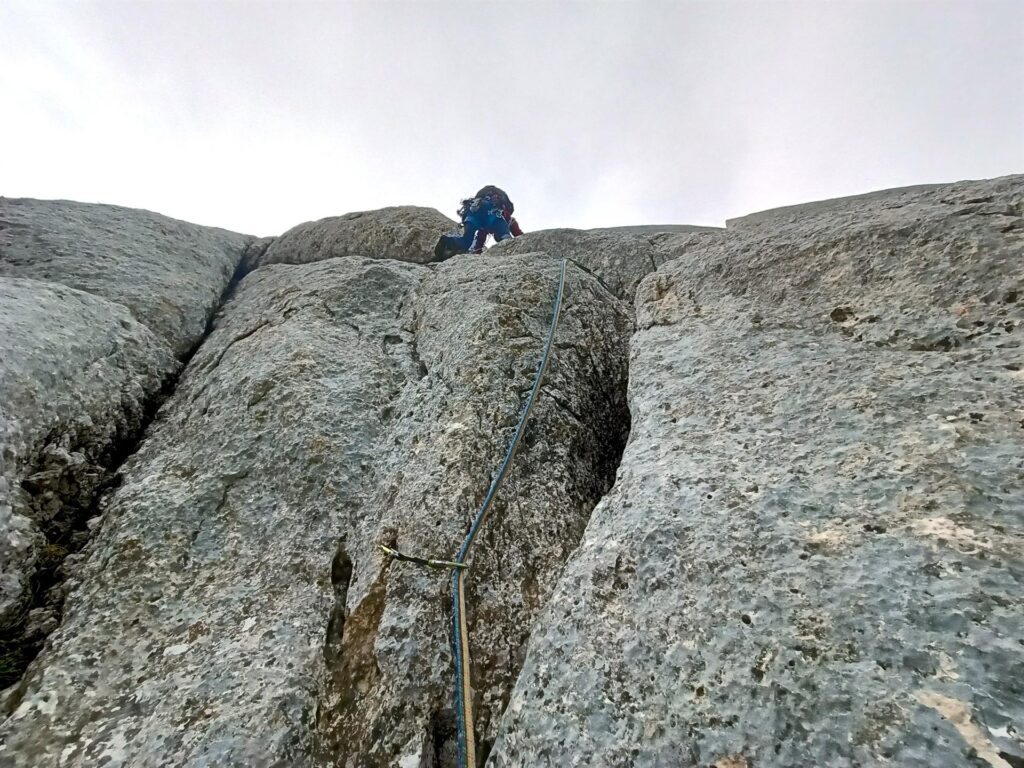 seguendo il sistema di fessure a Z verso un masso sporgente che va superato