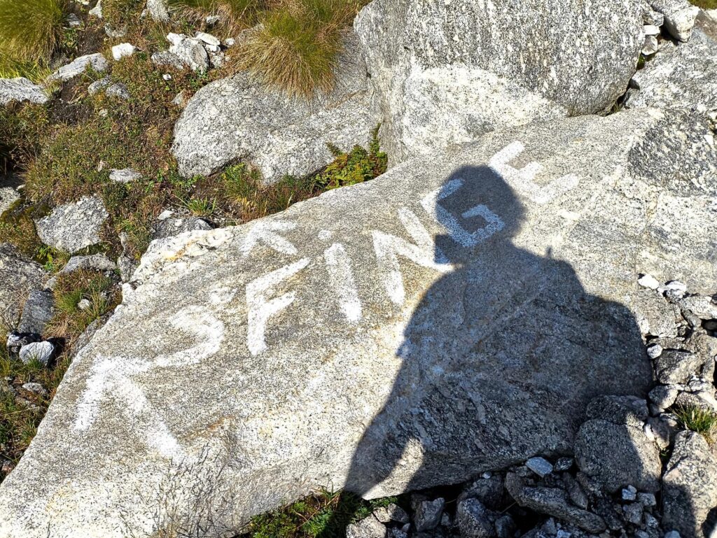 Si segue il sentiero per il passo fino a questa deviazione con scritta su masso