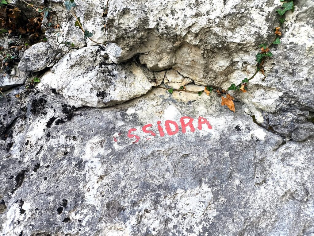 la scritta ormai sbiadita all'attacco della via (si parte su Clessidra)